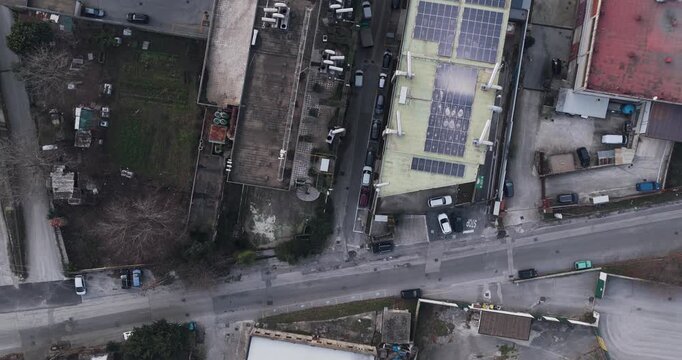 Aerial view of assorted rooftops, streets, and parked cars, creating a dense urban tapestry of textures and muted tones, Solofra, Campania, Italy.