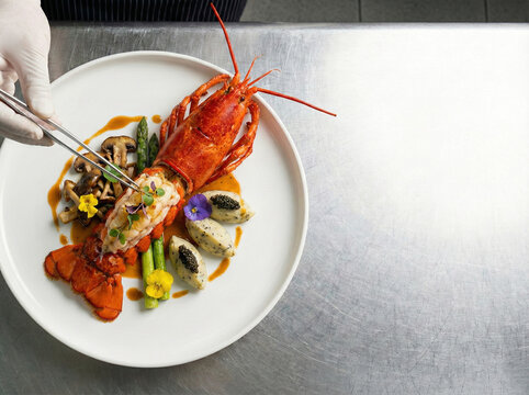 Professional Chef Plating Gourmet Lobster Dish with Tweezers