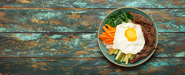 Traditional korean dish bibimbap with fried egg on top, top view