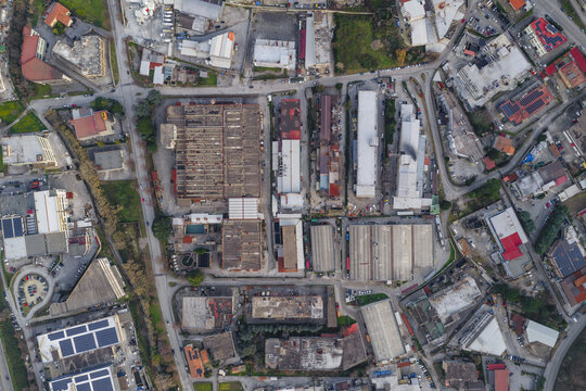 Aerial view of sun-drenched rooftops and industrial tanning factory buildings create a patchwork of textures and tones, a sprawling vista of urban life, Solofra, Campania, Italy.