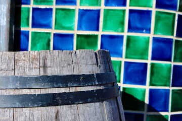 old wooden barrel with blue and green tiles