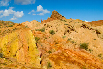 Fototapeta premium Colorful Fairytale canyon panorama landscape in Kyrgyzstan. Orange and yellow mountain valley Skazka canyon, rainbow mountain landscape all over the world in Pamir near Issyk Kul lake