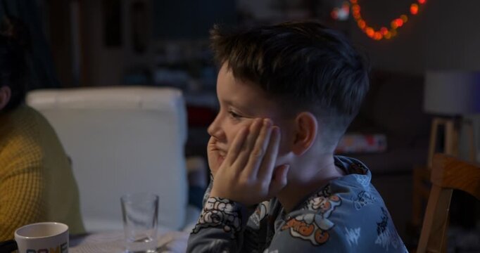 The boy looks thoughtful and doubtful as he analyses the clues to find the imposter.

