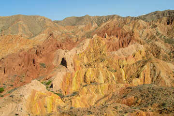 Fototapeta premium Colorful Fairytale canyon panorama landscape in Kyrgyzstan. Orange and yellow mountain valley Skazka canyon, rainbow mountain landscape all over the world in Pamir near Issyk Kul lake