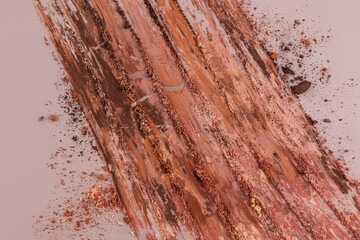 Close-up of chaotic strokes of eyeshadow in shades of brown, gold, beige. Bright layout for advertising decorative cosmetics. top view.