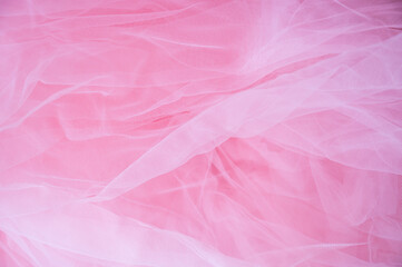 Fototapeta premium Abstract background of soft pink tulle fabric. Delicate mesh texture for wedding, bridal, or romantic feminine designs