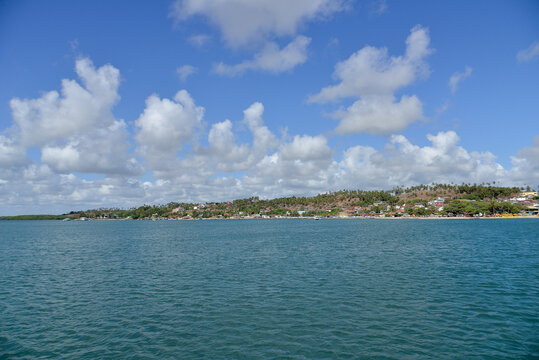 panoramic view of barra do cunha&uacute; village from the river, scenic coastal town landscape in rio grande do norte brazil, tropical riverside village with coconut trees and blue water, summer travel desti