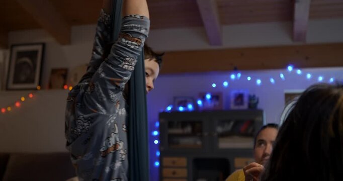 Aerial Yoga Enthusiast: A person practices aerial yoga, suspended in a hammock, achieving a sense of balance and flexibility in a warm and inviting indoor space.