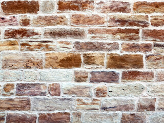 Naklejka premium Traditional Kampos stone wall background, Chios Island, Greece. Rectangular blocks in warm red brown colors.