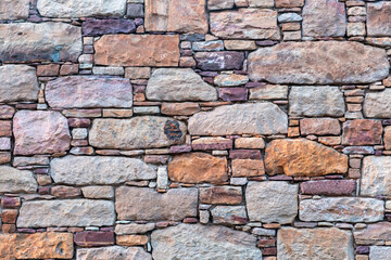 Obraz premium Traditional Kampos stone wall background, Chios Island, Greece. Rectangular blocks in warm red brown colors.