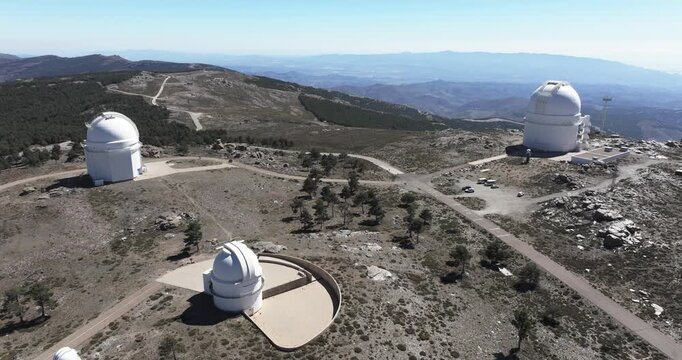 Drone aerial over Calar Alto Observatory domes in Tabernas, Spain, high altitude astronomy facility in arid mountain landscape with panoramic views