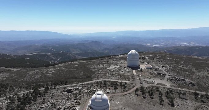 Aerial drone view of Calar Alto Observatory dome in Tabernas, Spain, isolated telescope facility on rocky mountain ridge with vast horizon