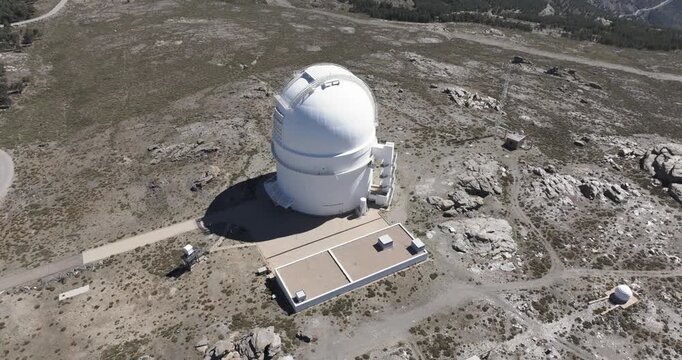 Drone aerial over Calar Alto Observatory dome and buildings, Tabernas Spain, scientific astronomy complex on rugged mountain plateau