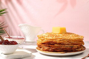 Maslenitsa concept. Delicious Russian pancakes with jam, soft cottage cheese, preserves, sour cream, and honey on a marble table. Healthy breakfast from natural ingredients, natural products