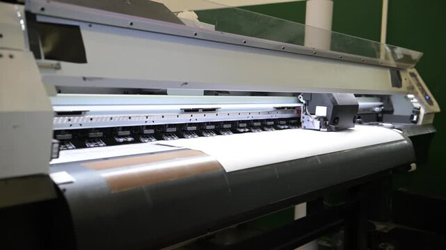 The process of printing a large-format printer in the production workshop of the printing house. Production of printing products