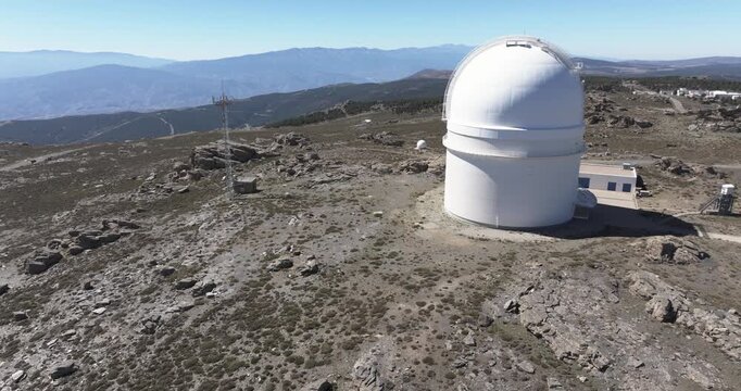 Drone aerial close view of Calar Alto Observatory dome, Tabernas Spain, astronomy telescope facility with barren mountain plateau backdrop