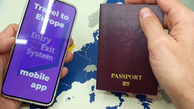 Hands placing a passport and a smartphone with the Entry Exit System mobile app on a map of Europe, a new requirement for non EU travelers entering the Schengen Area starting in 2025