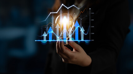 A business professional holds a light bulb with dynamic graphs in the background, symbolizing innovation, growth, and success in the finance world. Perfect for corporate themes. Scalp