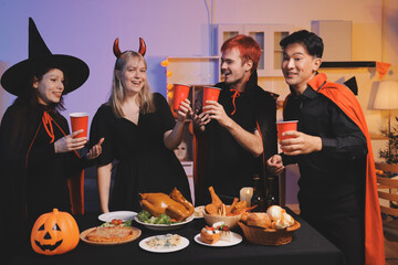 Friends enjoying a Halloween party at a bar making a toast