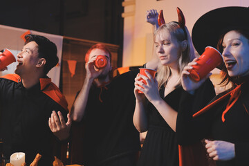Friends enjoying a Halloween party at a bar making a toast