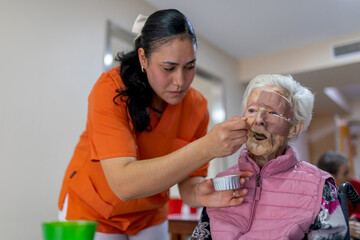 Caregiver assisting senior woman with wound dressing