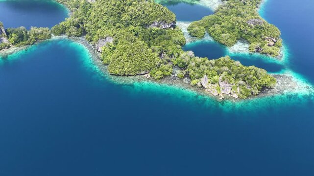 Shallow coral reefs fringe the beautiful islands of Pef, Raja Ampat, Indonesia. This region harbors spectacular marine biological diversity and is a popular destination for divers and snorkelers.