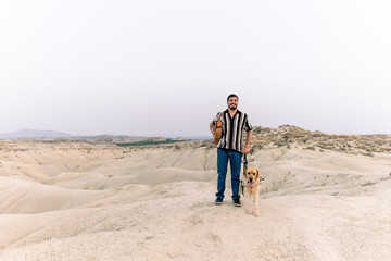 Blind man with guide dog in arid desert landscape