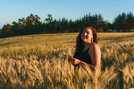 Joyful woman in a golden field at sunset