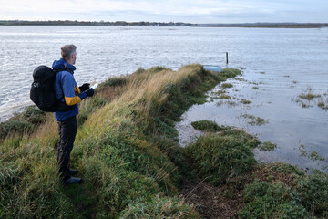 Researcher Monitoring a Coastal Salt Marsh for Habitat Conservation and Sea Level Rise Adaptation