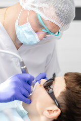 Dentist performing dental checkup on young patient
