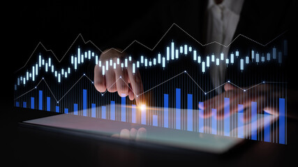 A business professional interacts with a tablet device displaying glowing data trends and graphs. This image represents modern analytics in finance and technology. Scalp