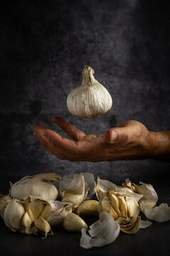 Garlic levitating above a hand with cloves below