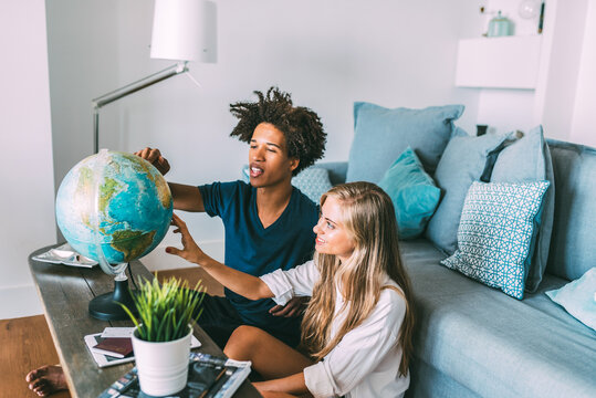 Couple exploring a globe together at home