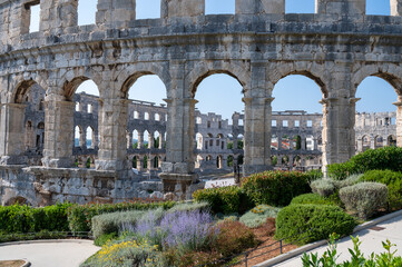 Obraz premium Part of the amphitheater and a planted walkway in Pula, Croatia