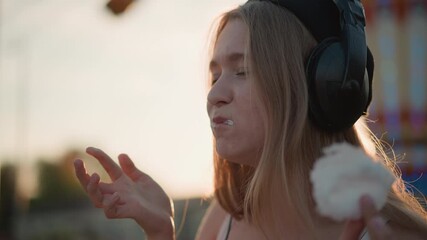 Woman enjoys sweet treat, Female relishes sugary delight joyfully, Lady finds happiness in fluffy cotton candy, Woman experiences bliss while indulging in sugary cotton candy extravagance