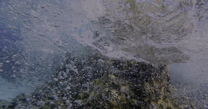 Dynamic flow of water under a wave near a rock formation in the ocean