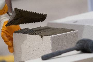 The bricklayer is working. Building a wall of aerated concrete. Gasbeton wall