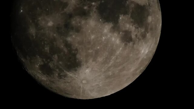 Timelapse video captured with super zoom of a full moon, revealing detailed lunar surface features as the Moon slowly moves across the night sky, 2022