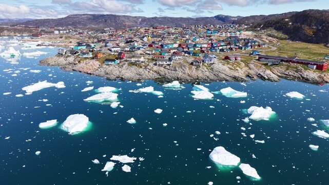 GREENLAND - 11.4.2025 - Amazing aerial footage moving over ice floes towards a coastal Greenland village.