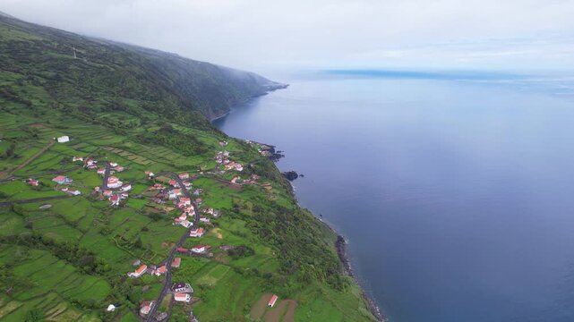 AZORES - 11.3.2025 - Beautiful aerial footage drawing back from a remote coastal community on the Azores' Sao Jorge Island.