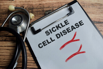 Concept of sickle cell disease write on clipboard isolated on Wooden Table.