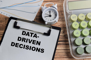 Concept of data driven decisions write on clipboard isolated on Wooden Table.