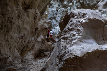 Low angle view of narrow Saklikent Canyon with polished limestone walls. Giant smooth rocks eroded by water and sand in mountain gorge. September, Fethiye region, Turkey.