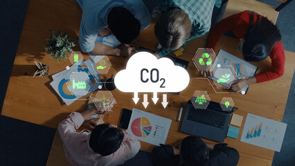 A diverse team engages in collaborative strategy planning focused on reducing CO2 emissions. Visual data and charts enhance discussions about sustainability and environmental impact. Trope