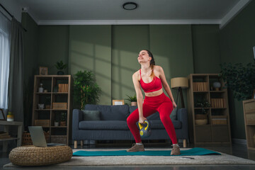 Young woman performing kettle bell workout at home for fitness