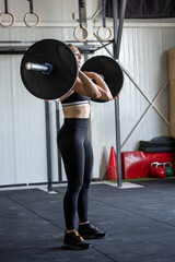 Strong woman lifting a barbell during squat exercise
