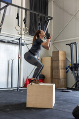 Athletic woman performing box jumps during crossfit training