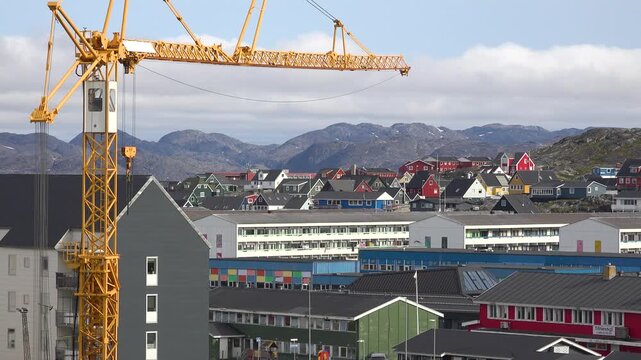 GREENLAND - 11.4.2025 - Very good aerial view of a construction crane towering over colorful buildings in Nuuk, Greenland.