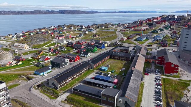 GREENLAND - 11.4.2025 - Amazing aerial footage moving over colorful buildings of Nuuk, Greenland, bound for the coast.