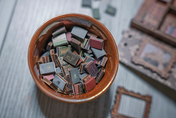 Detailed miniature wooden library interior with spiral staircase, bookshelves and tiny furniture. Close-up of handcrafted dollhouse room showing creativity, hobby, craftsmanship and vintage design. © Alisa